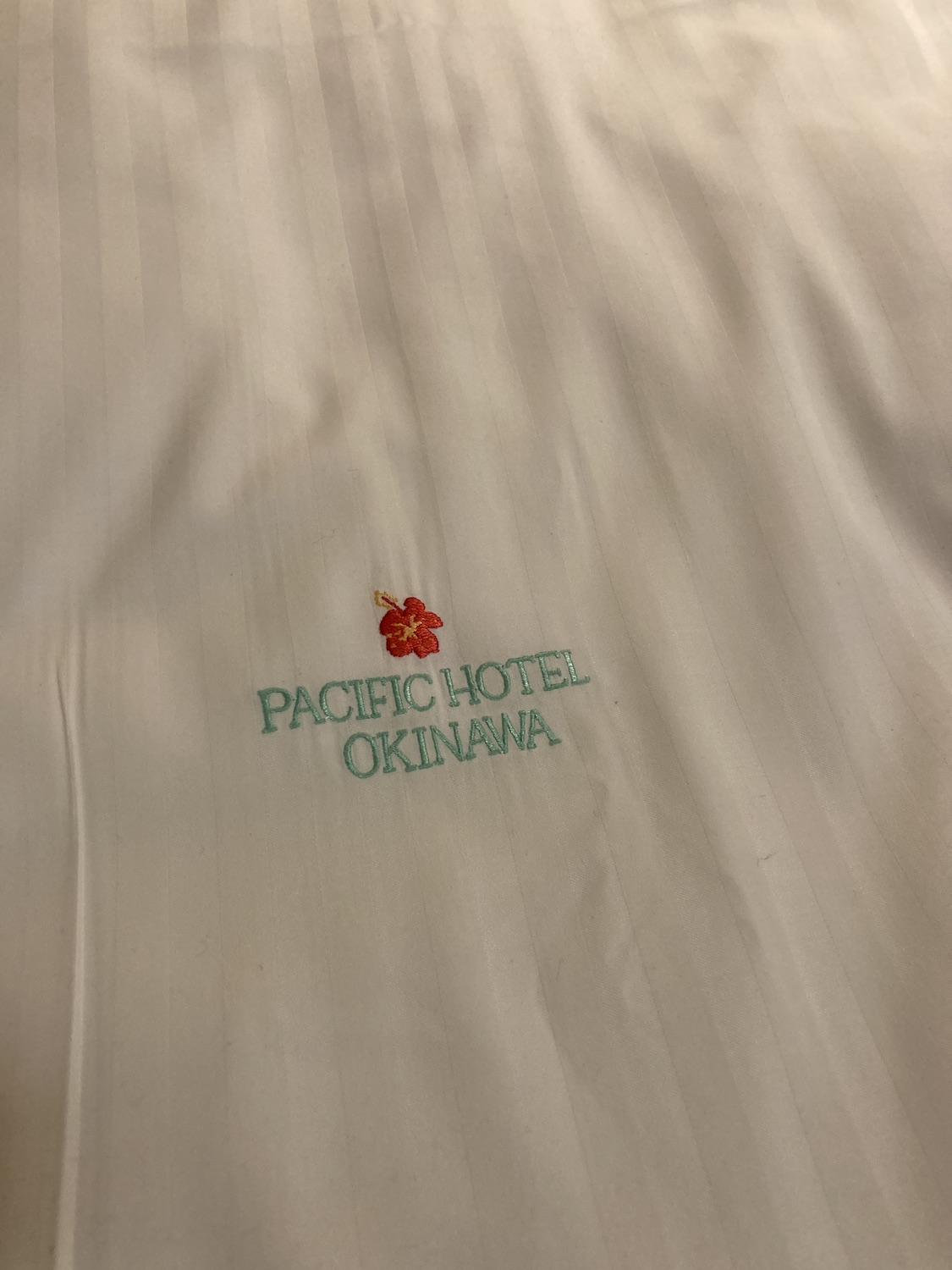 ベッドのシーツにはオリジナルロゴの刺繍入り。